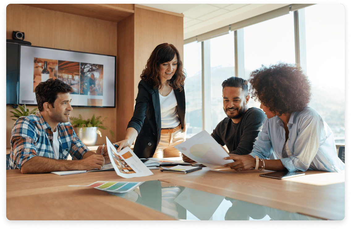 
                  Group of cheerful marketing professionals collaborating around a conference table,
                  with documents in hand, representing the expert, US-based, QuickBooks-certified bookkeeping
                  teams provided by the service.
                