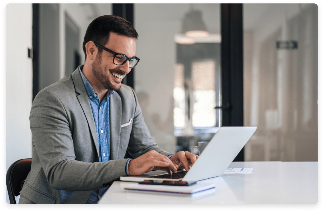 
                  Cheerful businessman working on a laptop, indicative of the professional and strategic services
                  offered by fractional CFOs to private equity-backed firms, focusing on financial growth and decision-making.
                