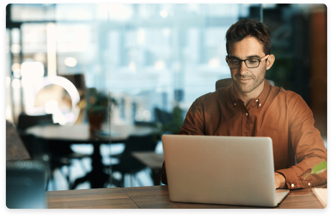 
                  Focused man working on a laptop in a modern office setting, symbolizing professional
                  financial services for company objectives, data structure design, and financial organization.
                